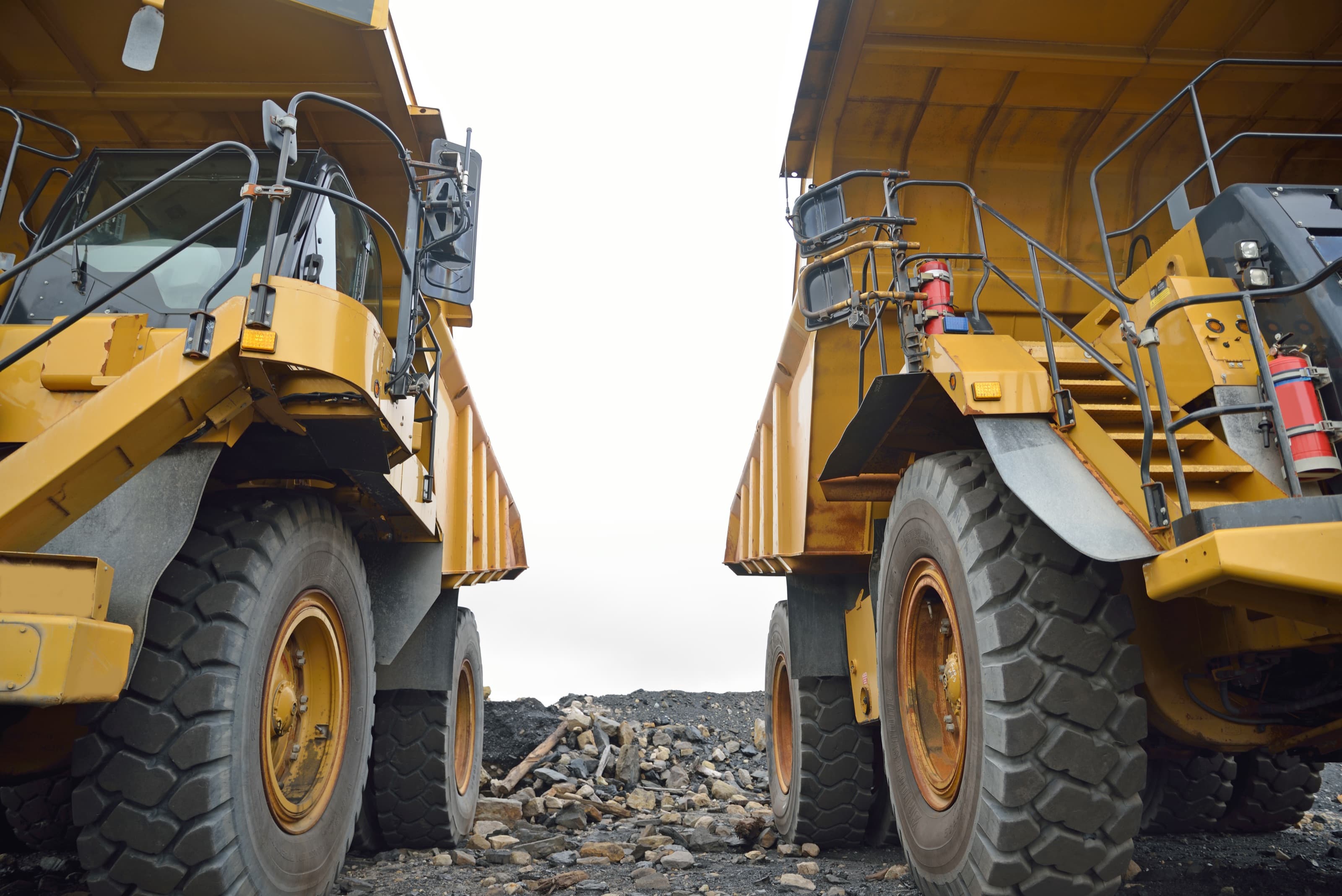 Two heavy dump trucks on a work site