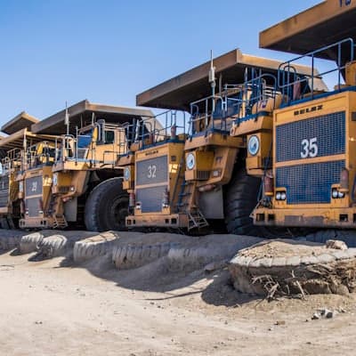 A line of haul trucks parked at a quarry