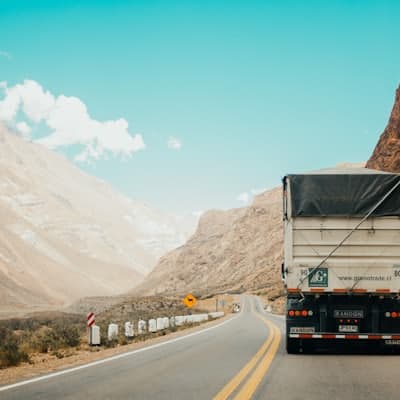 A truck and trailer on a highway through the mountains